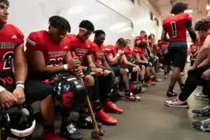 Westside High School defensive lineman Rj Eckhardt (11) and teammates listen to Westside Higih School head coach Paul Limongi before a game between Lincoln North East and Westside in Omaha, NE on Thursday October 19tth, 2023. Photo by Eric Francis