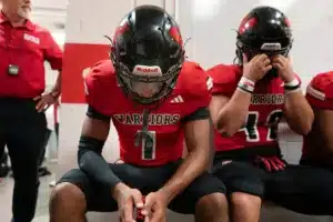 Westside High School Caleb Benning (1) and teammates listen to Westside Higih School head coach Paul Limongi before a game between Lincoln North East and Westside in Omaha, NE on Thursday October 19tth, 2023. Photo by Eric Francis