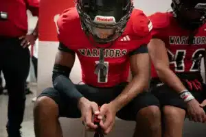 Westside High School Caleb Benning (1) and teammates listen to Westside Higih School head coach Paul Limongi before a game between Lincoln North East and Westside in Omaha, NE on Thursday October 19tth, 2023. Photo by Eric Francis