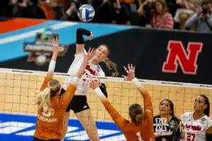 Nebraska Cornhusker middle blocker Andi Jackson (15) spikes the ball against Texas Longhorn middle blocker Bella Bergmark (5) and Texas Longhorn setter Ella Swindle (1) in the second set during the NCAA Finals on Sunday, December 17, 2023, in Tampa, Florida. Photo by John S. Peterson.