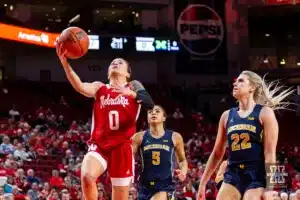 Nebraska Cornhusker guard Darian White (0) makes a lay up against Michigan Wolverine forward Chyra Evans (22) in the first half during a college basketball game on Wednesday, January 17, 2024, in Lincoln, Nebraska. Photo by John S. Peterson.