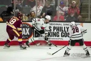 Omaha forward Ty Mueller (19) battles for the puck against Minn. Duluth defenseman Joey Pierce (18) during a college hockey match on Friday, February 2, 2024, in Omaha, Nebraska. Photo by John S. Peterson.