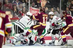 Omaha defenseman Jacob Guevin (10) and Minn. Duluth forward Jack Smith (12) battle it out in the second period during a college hockey match on Friday, February 2, 2024, in Omaha, Nebraska. Photo by John S. Peterson.