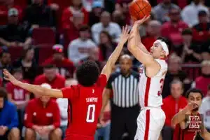 Nebraska Cornhusker guard Keisei Tominaga (30) makes a three point shot against Rutgers Scarlet Knight guard Derek Simpson (0) in the first half during a college basketball game Sunday, March 3, 2024, in Lincoln, Neb. Photo by John S. Peterson.