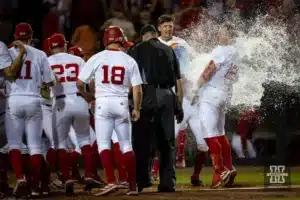 Nebraska Cornhusker Cole Evans (12) celebrates hitting a three-run homer in the tenth inning with a Gatorade bath at home for a walk-off win against the Indiana Hoosiers during an NCAA college baseball game Saturday, May 5, 2024, in Lincoln, Neb. Photo by John S. Peterson.