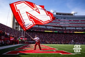 Nebraska Cornhusker Spirit team member waves the flag after a touchdown against the Wisconsin Badgers during a college football game Saturday, November 23, 2024 in Lincoln, Nebraska. Photo by John S. Peterson.