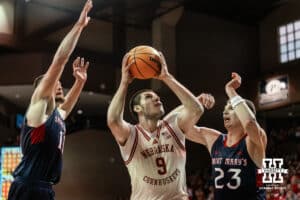 Nebraska Cornhusker forward Berke Buyuktuncel (9) puts a layup against St. Mary's Gaels forward Paulius Murauskas (23) and center Mitchell Saxen (11) during a college basketball game Sunday, November