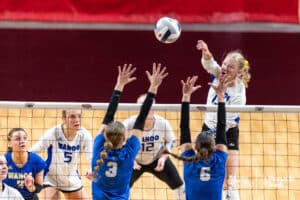 Wahoo's McKenna Smith (13) spikes the ball against Pierce's Hadleigh Collison (3) and Skylar Scholting (6) during the semi-finals of the 2024 NSAA Volleyball Championships Friday, November 8, 2024, in Lincoln, Nebraska. Photo by John S. Peterson.