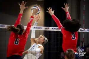 Creighton Bluejay outside hitter Ava Martin (8) tips the ball over against St. John's Red Storm middle blocker Ludovica Zola (6) and setter Erin Jones (3) in the third set during a college volleyball match Friday, November 1, 2024, in Omaha, Nebraska. Photo by John S. Peterson.