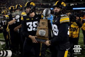 Iowa Hawkeyes long snapper Luke Elkin (39) and punter Ty Nissen (99) carry the Hero's Trophy back to the locker room after the win over the Nebraska Cornhuskers during a college football game Friday, November 29, 2024, in Iowa City, Iowa. Photo by John S. Peterson.