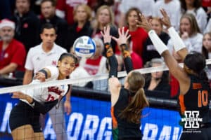 Nebraska Cornhuskers outside hitter Taylor Landfair (12) spikes the ball around Miami Hurricanes middle blocker Ashley Carr (4) and outside hitter Flormarie Heredia Colon (10) in the first set during the second round of the NCAA volleyball tournament Saturday, December 7, 2024, in Lincoln, Nebraska. Photo by John S. Peterson.