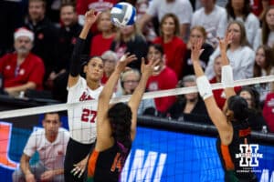 Nebraska Cornhuskers outside hitter Harper Murray (27) hits the ball against Miami Hurricanes Dalia Wilson (14) and setter Ariana Rodriguez (6) in the first set during the second round of the NCAA volleyball tournament Saturday, December 7, 2024, in Lincoln, Nebraska. Photo by John S. Peterson.