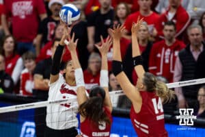 Nebraska Cornhuskers outside hitter Taylor Landfair (12) tips the ball against Wisconsin Badgers middle blocker CC Crawford (9) and Anna Smrek in the first set during the final regional match in the NCAA championship Sunday, December 15, 2024, in Lincoln, Nebraska. Photo by John S. Peterson.