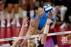 Nebraska Cornhuskers middle blocker Rebekah Allick (5) and Nebraska Cornhuskers setter Bergen Reilly (2) jump to block a shot from Wisconsin Badgers outside hitter Sarah Franklin (13) in the first set during the final regional match in the NCAA championship Sunday, December 15, 2024, in Lincoln, Nebraska. Photo by John S. Peterson.