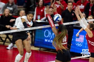 Nebraska Cornhuskers outside hitter Taylor Landfair (12) blasts the ball through Wisconsin Badgers opposite Devyn Robinson (10) arms in the first set during the final regional match in the NCAA championship Sunday, December 15, 2024, in Lincoln, Nebraska. Photo by John S. Peterson.