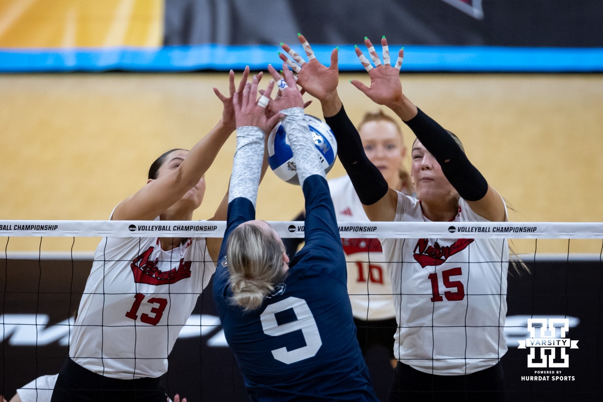 Nebraska Cornhuskers outside hitter Merritt Beason (13) and Andi Jackson battle Penn State Nittany Lions outside hitter Jess Mruzik (9) at the net during the semi-final round in the NCAA championship Thursday, December 19, 2024, in Louisville, Kentucky. Photo by John S. Peterson.