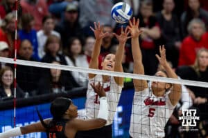 Nebraska Cornhuskers middle blocker Rebekah Allick (5) and outside hitter Merritt Beason (13) reach for the ball against Miami Hurricanes outside hitter Flormarie Heredia Colon (10) during the second round of the NCAA volleyball tournament Saturday, December 7, 2024, in Lincoln, Nebraska. Photo by John S. Peterson.