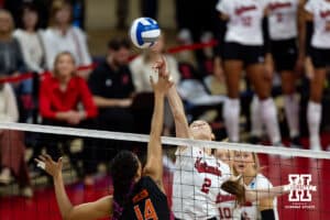 Nebraska Cornhuskers setter Bergen Reilly (2) and Miami Hurricanes opposite Dalia Wilson (14) reach for the ball during the second round of the NCAA volleyball tournament Saturday, December 7, 2024, in Lincoln, Nebraska. Photo by John S. Peterson.