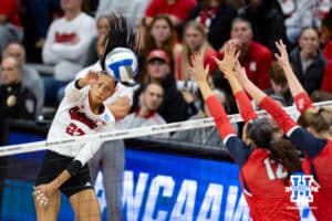 Nebraska Cornhuskers outside hitter Harper Murray (27) spikes the ball against Dayton Flyers middle hitter Liana Sarkissian (12) and outside hitter Brooke Smith (1) during the first regional match in the NCAA championship Friday, December 13, 2024, in Lincoln, Nebraska. Photo by John S. Peterson.