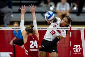 Nebraska Cornhuskers outside hitter Taylor Landfair (12) spikes the ball past down the line against Wisconsin Badgers setter Charlie Fuerbringer (24) in the second set during the final regional match in the NCAA championship Sunday, December 15, 2024, in Lincoln, Nebraska. Photo by John S. Peterson.