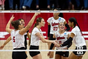 Nebraska Cornhuskers setter Bergen Reilly (2) and outside hitter Taylor Landfair (12) give each other fives against the Wisconsin Badgers in the second set during the final regional match in the NCAA championship Sunday, December 15, 2024, in Lincoln, Nebraska. Photo by John S. Peterson.