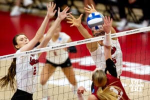 Nebraska Cornhuskers middle blocker Rebekah Allick (5) and Bergen Reilly jump up to block Wisconsin Badgers outside hitter Sarah Franklin (13) in the third setduring the final regional match in the NCAA championship Sunday, December 15, 2024, in Lincoln, Nebraska. Photo by John S. Peterson.