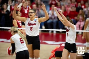 Nebraska Cornhuskers middle blocker Rebekah Allick (5) and Bergen Reilly celebrate a point against the Wisconsin Badgers in the third set during the final regional match in the NCAA championship Sunday, December 15, 2024, in Lincoln, Nebraska. Photo by John S. Peterson.