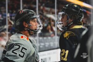 Forward Cameron Mitchell speaking with Forward Jake Southgate of Lindenwood during a hockey match at Baxter Arena on Saturday, December 14, 2024, in Omaha, Nebraska. Photo by Collin Stilen.