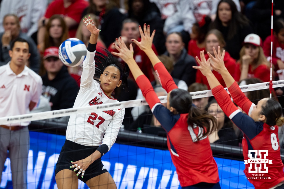 Nebraska Cornhuskers outside hitter Harper Murray (27) spikes the ball against Dayton Flyers middle hitter Liana Sarkissian (12) and setter Alyssa Miller (8) during the first regional match in the NCAA championship Friday, December 13, 2024, in Lincoln, Nebraska. Photo by John S. Peterson.