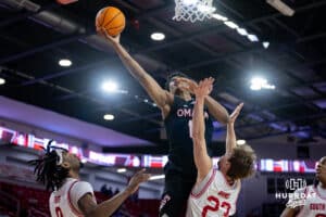 Omaha Mavericks forward Marquel Sutton (10) makes a layup against South Dakota Coyotes guard Paul Bruns (23) and guard Chase Forte (9) in the second half during a college basketball game, Wednesday, January 29, 2025, in Vermillion, South Dakota. Photo by John S. Peterson.