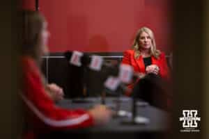 Looking through the glass in the doorway, Nebraska head volleyball coach watches the players answer queations after the Welcome to Dani Busboom-Kelly Celebration event Thursday, February 6, 2025 in Lincoln, Nebraska. Photo by John S. Peterson.