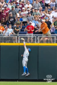UCLA Bruin infielder A.J. Salgado (24) jumps to try and catch the home run ball in the first inning against the LSU Tigers during the College World Series on Monday, June 16, 2025 in Omaha, Nebraska. Photo by John S. Peterson.