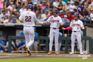 LSU Tiger first baseman Jared Jones (22) crosses home plate after hitting a home run with teammates Jake Brown and Steven Milam ready to celebrate against the UCLA Bruins during the College World Series on Monday, June 16, 2025 in Omaha, Nebraska. Photo by John S. Peterson.