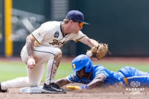 Murray State Racer Infielder Dom Decker (12) upustí míč s UCLA Bruin Dean West (36), který ukradl druhý v první směně během světové série College v sobotu 14. června 2025 v Omaha v Nebrasce. Foto John S. Peterson.