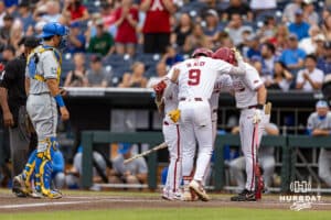 Arkansas Razorback infielder Wehiwa Aloy (9) runs home with Charles Davalan, Logan Maxwell, and the batboy waiting after hitting a two-run home run against the UCLA Bruins in the first inning during the College World Series on Tuesday, June 17, 2025 in Omaha, Nebraska. Photo by John S. Peterson.