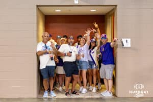 Fans take cover from the rain in the men's room entrance during the College World Series game between the LSU Tigers and the UCLA Bruins on Monday, June 16, 2025 in Omaha, Nebraska. Photo by John S. Peterson.