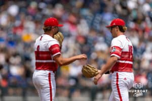 Louisville Cardinal pitcher Jake Schweitzer (8) hands the ball over to TJ Schlageter (19) against the Coastal Carolina Chanticleers in the third inning during the College World Series on Wednesday, June 18, 2025 in Omaha, Nebraska. Photo by John S. Peterson.
