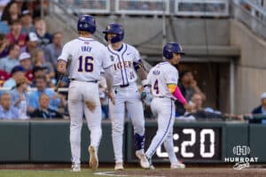 LSU Tiger Ethan Frey (16) and Steven Milam (4) celebrate their runs with Daniel Dickinson (14) in the sixth inning during the College World Series on Wednesday, June 18, 2025 in Omaha, Nebraska. Photo by John S. Peterson.