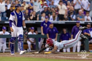Arkansas Razorback infielder Wehiwa Aloy (9) slides home on a bad throw to third in the eighth inning against the LSU Tigers during the College World Series on Wednesday, June 18, 2025 in Omaha, Nebraska. Photo by John S. Peterson.