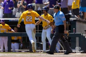LSU Tiger first baseman Jared Jones (22) scores a run with Jake Brown in the fourth inning against the Coastal Carolina Chanticleers in the second game of the finals during the College World Series on Sunday, June 22, 2025 in Omaha, Nebraska. Photo by John S. Peterson.