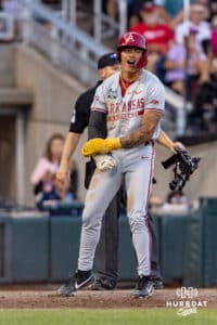 Arkansas Razorback infielder Wehiwa Aloy (9) celebrates scoring in the eighth inning against the LSU Tigers during the College World Series on Wednesday, June 18, 2025 in Omaha, Nebraska. Photo by John S. Peterson.