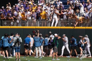 LSU Tiger utility Jake Brown (7) jumps into the crowd during a baseball game Sunday June 22nd 2025 in Omaha Nebraska. Photo by Brandon Tiedemann.
