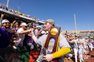 LSU Tiger first baseman Jared Jones (22) carries the trophy as he gives high fives to the fans after the win over the Coastal Carolina Chanticleers in the second game of the finals during the College World Series on Sunday, June 22, 2025 in Omaha, Nebraska. Photo by John S. Peterson.