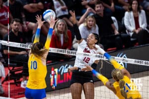 Nebraska Cornhusker Taylor Landfair (12) spikes the ball against Pittsburgh Panthers Marina Pezelj (10) and Bre Kelley (21) in the first set during the AVAC Showcase volleyball match on Friday, Aug. 22, 2025, in Lincoln, Nebraska. Photo by John S. Peterson.