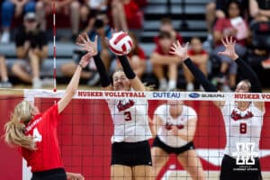 Nebraska alumnus Ally Batenhorst (14) spikes the ball against Nebraska Cornhuskers Allie Sczech (3) and Kenna Cogill (8) in the third set during the Nebraska alumni match on Saturday, Aug. 16, 2025 in Lincoln, Nebraska. Photo by John S. Peterson.