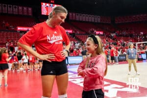 Nebraska alumnus Gina Mancuso-Prososki (7) talks with a young fan after the Nebraska alumni match against the Nebraska Cornhuskers on Saturday, Aug. 16, 2025 in Lincoln, Nebraska. Photo by John S. Peterson.