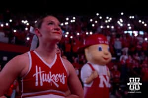 Nebraska Cornhusker cheerleader watches the hype video with the light show in the background during a college volleyball match against the Iowa Hawkeyes on Thursday, Nov. 20, 2025, in Lincoln, Nebraska. Photo by John S. Peterson.
