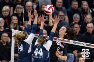 Nebraska Cornhusker opposite Virginia Adriano (9) spikes the ball against Penn State Nittany Lion right side hitter Caroline Jurevicius (14) and middle blocker Maggie Mendelson (44), both former Huskers, in the third set during a volleyball match on Friday, Nov. 28, 2025, in Lincoln, Nebraska. Photo by John S. Peterson.