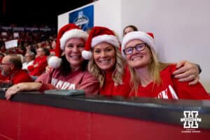 Santa hat-wearing Nebraska Cornhusker fans pose for a photo during the first round of the NCAA volleyball tournament on Friday, Dec. 5, 2025, in Lincoln, Nebraska. Photo by John S. Peterson.