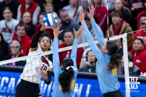 Nebraska Cornhusker outside hitter Taylor Landfair (12) spikes the ball against LIU Shark middle hitter Sara Garcia (24) and outside hitter Sara van Gisteren (18) in the first set during the first round of the NCAA volleyball tournament on Friday, Dec. 5, 2025, in Lincoln, Nebraska. Photo by John S. Peterson.